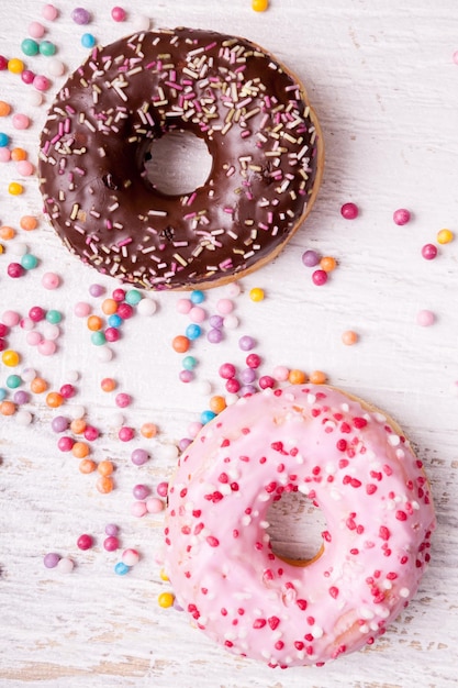 Vista aérea de donuts em e doce doce em fundo branco de madeira. Junk food deliciosa