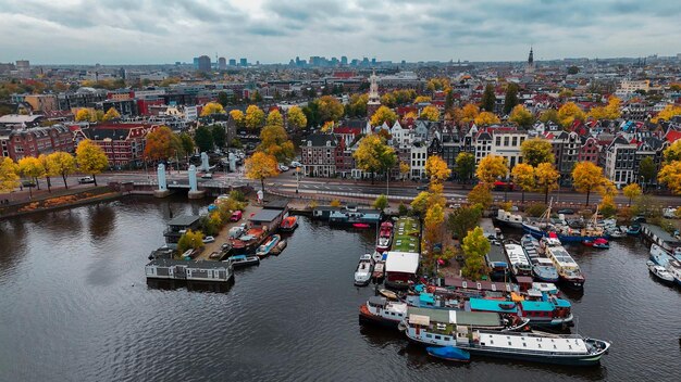 Foto vista aérea de drone de amsterdã paisagem urbana de outono casas antigas estreitas canais barcos pássaros vista de olho