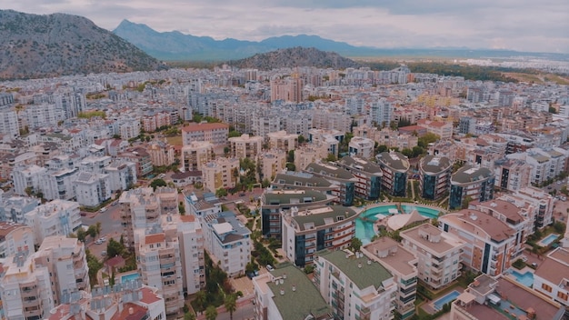 Vista aérea de drones sobre uma grande cidade tendo como pano de fundo montanhas Vista superior de casas e hotéis