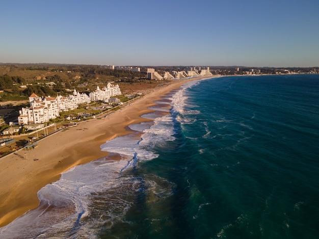 Vista aérea de edifícios brancos modernos ao lado de uma praia deserta em algarrobo chile