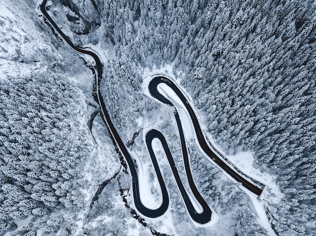 Vista aérea de estrada e floresta em paisagem coberta de neve