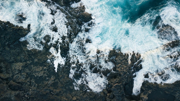 Vista aérea de falésias e espuma das ondas do mar. Oceano Atlântico nas Ilhas Canárias