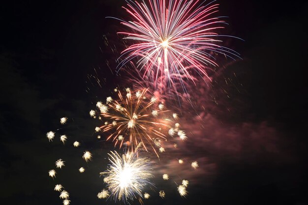 Vista aérea de fogos de artifício brilhantes explodindo com luzes coloridas contra o céu noturno escuro no feriado do Dia da Independência dos EUA