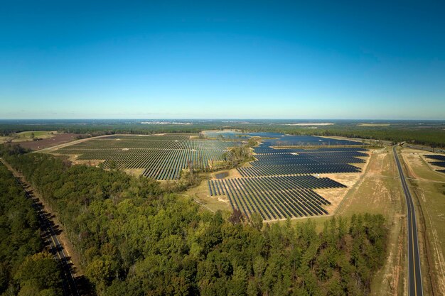 Vista aérea de grande usina elétrica sustentável com fileiras de painéis solares fotovoltaicos para produção de energia elétrica limpa Conceito de eletricidade renovável com emissão zero