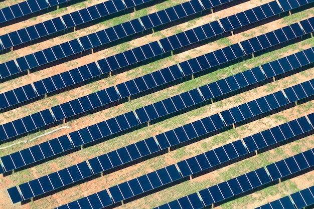 Vista aérea de grande usina elétrica sustentável com fileiras de painéis solares fotovoltaicos para produção de energia elétrica limpa Conceito de eletricidade renovável com emissão zero