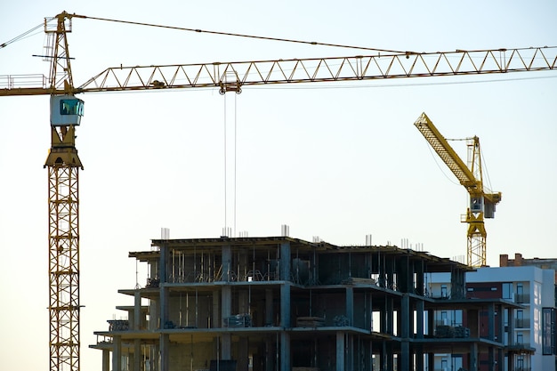 Vista aérea de guindastes de torre e altos edifícios de apartamentos residenciais em construção. desenvolvimento imobiliário.