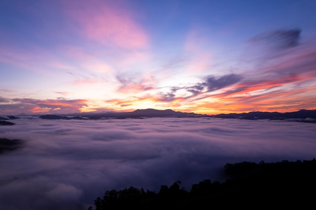 Vista aérea de ondas de nevoeiro fluindo na floresta tropical de montanha belo nascer do sol ou céu do pôr do sol Imagem de vista de olho de pássaro sobre as nuvens Fundo de natureza incrível com nuvens e montanhas na Tailândia