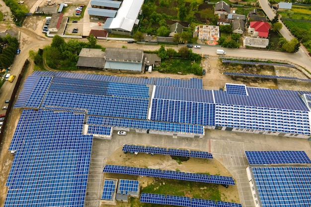 Vista aérea de painéis solares fotovoltaicos azuis montados no telhado de um prédio industrial para a produção de eletricidade ecológica limpa. Produção do conceito de energia renovável.