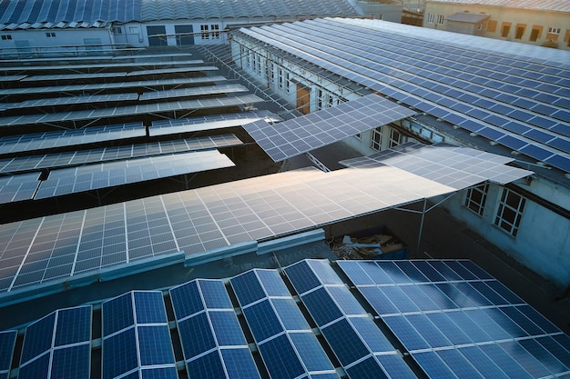 Vista aérea de painéis solares fotovoltaicos azuis montados no telhado do edifício industrial para produzir eletricidade ecológica verde Produção do conceito de energia sustentável