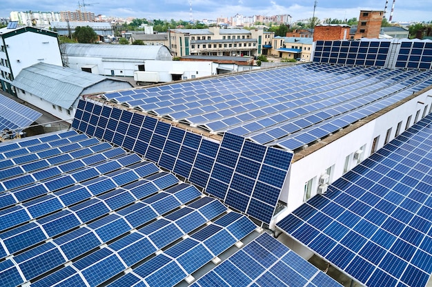 Vista aérea de painéis solares fotovoltaicos azuis montados no telhado do edifício industrial para produzir eletricidade ecológica verde Produção do conceito de energia sustentável