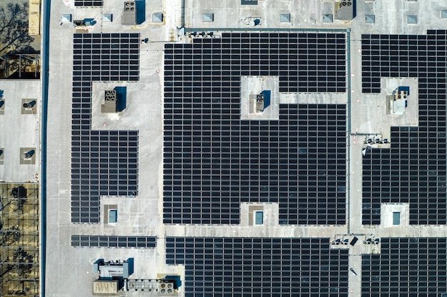 Vista aérea de painéis solares fotovoltaicos azuis montados no telhado do edifício industrial para produzir eletricidade ecológica verde Produção do conceito de energia sustentável