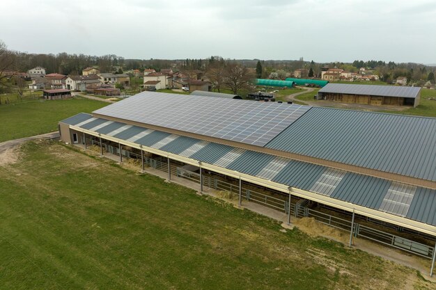 Vista aérea de painéis solares fotovoltaicos azuis montados no telhado do prédio da fazenda para produzir eletricidade ecológica limpa Produção do conceito de energia renovável