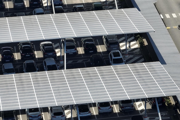 Vista aérea de painéis solares instalados sobre estacionamento com carros estacionados para geração efetiva de energia limpa