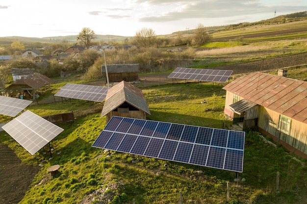 Vista aérea de painéis solares no quintal de vila rural verde.