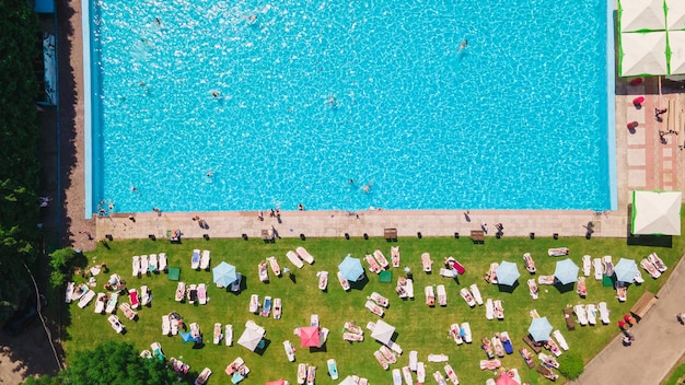 Vista aérea de pessoas descansando tomando sol perto da piscina da cidade ao ar livre dia ensolarado de verão