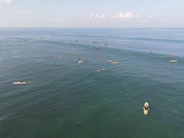 Vista aérea de pessoas surfando nas ondas com pranchas de surf durante as férias em Bali Indonésia