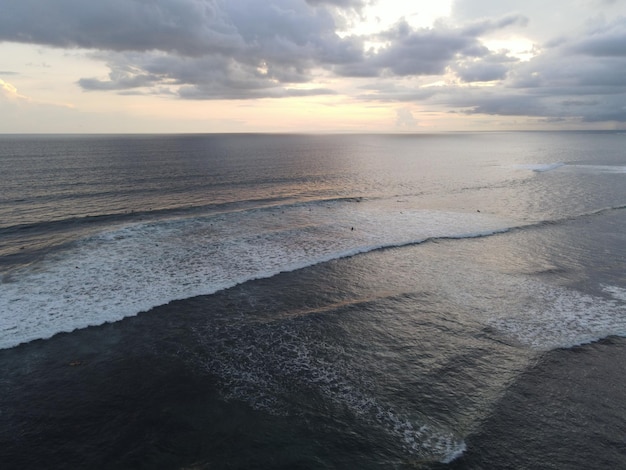 Vista aérea de pessoas surfando nas ondas com pranchas de surf durante as férias em Bali Indonésia