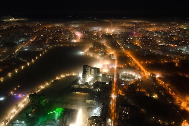 Vista aérea de prédios de apartamentos altos e ruas iluminadas brilhantes na área residencial da Ucrânia da cidade de IvanoFrankivsk à noite Paisagem urbana escura