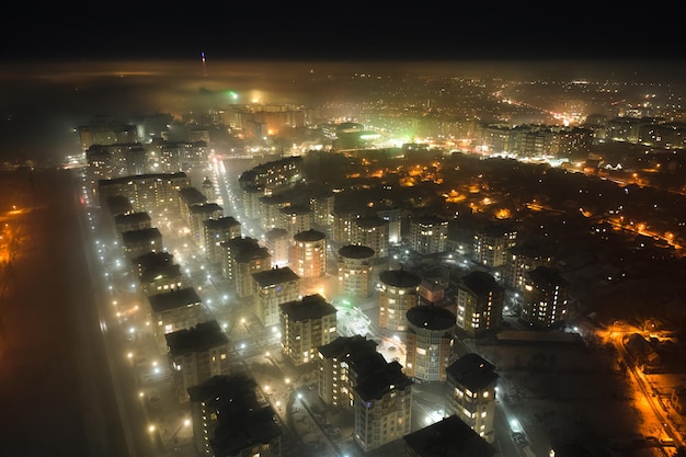 Vista aérea de prédios de apartamentos altos e ruas iluminadas brilhantes na cidade de Ivano-Frankivsk, área residencial da Ucrânia à noite. Paisagem urbana escura