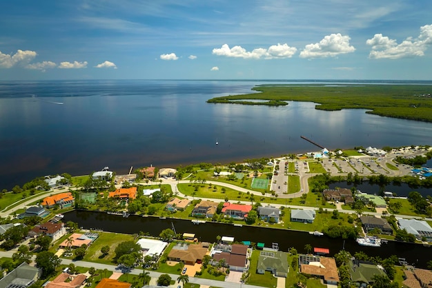 Vista aérea de subúrbios residenciais com casas de um andar localizadas perto de zonas úmidas de vida selvagem com vegetação tropical verde na costa do mar Vivendo perto da natureza no conceito de clima quente