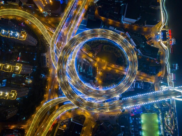 Foto vista aérea de trilhas de luz em estradas elevadas na cidade à noite