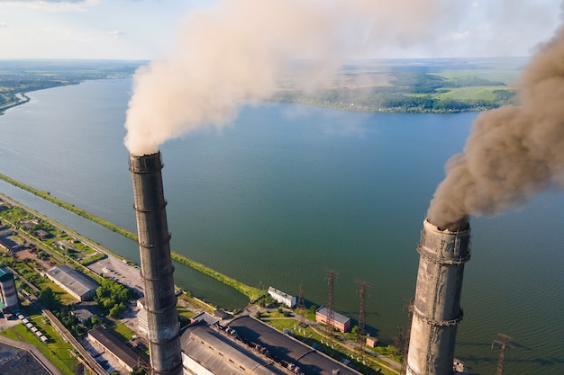 Vista aérea de tubos altos de usina de carvão com atmosfera poluente de chaminé preta. Produção de eletricidade com conceito de combustível fóssil.