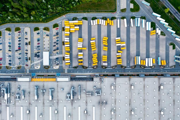 Vista aérea de um armazém caminhões com reboques ficam em um estacionamento perto de um armazém logístico armazéns de uma loja online uma zona industrial uma vista de grande altura