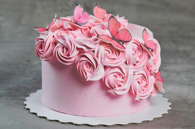 Vista aérea de um bolo recém-cozido decorado com rosas de açúcar rosa exibidas em um suporte de bolo sobre um fundo preto com copyspace