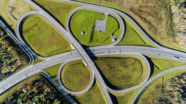 Vista aérea de um cruzamento de rodovias Fotografia aérea de uma rodovia que atravessa a floresta