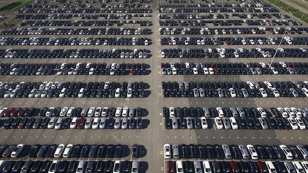 Vista aérea de um enorme estacionamento com carros novos