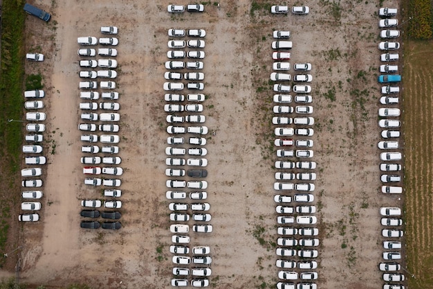 Vista aérea de um grande parque de estacionamento com carros brancos