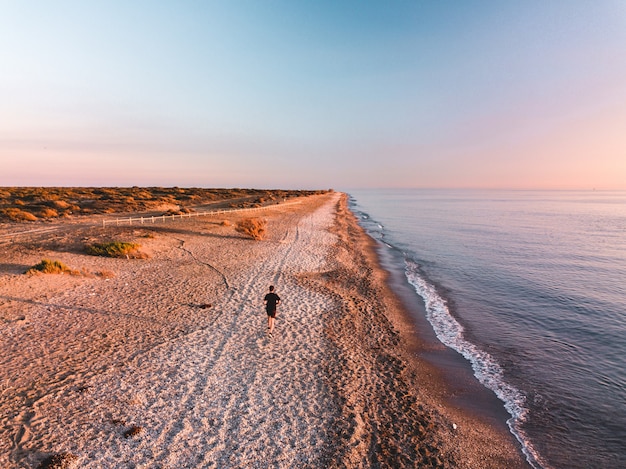 Vista aérea de um homens correndo no pôr do sol