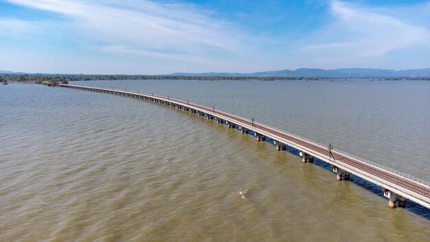 Vista aérea de um incrível trem de viagem estacionado em uma ponte ferroviária flutuante sobre a água