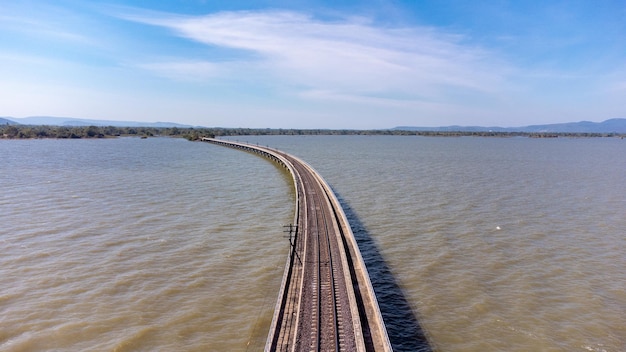 Vista aérea de um incrível trem de viagem estacionado em uma ponte ferroviária flutuante sobre a água