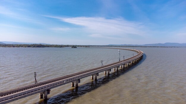 Vista aérea de um incrível trem de viagem estacionado em uma ponte ferroviária flutuante sobre a água