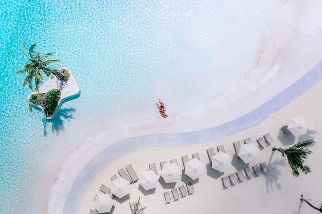 Vista aérea de um jovem casal descansando à beira-mar