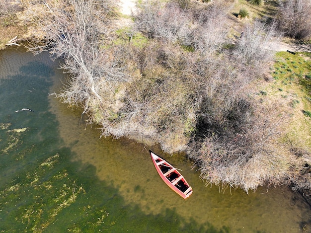 Vista aérea de um pequeno barco vermelho no lago da floresta de Longoz na temporada de inverno. Florestas de Karacabey Longoz. Karacabey, Bursa, Turquia