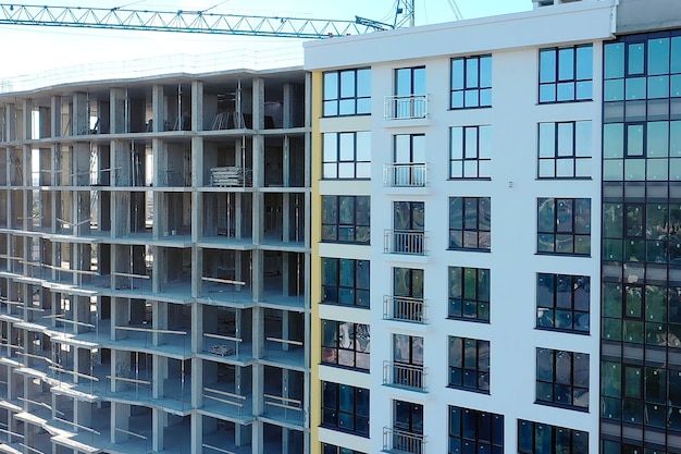 Vista aérea de um prédio residencial alto em construção. Muitas janelas na fachada do novo prédio de apartamentos em construção. Desenvolvimento imobiliário.