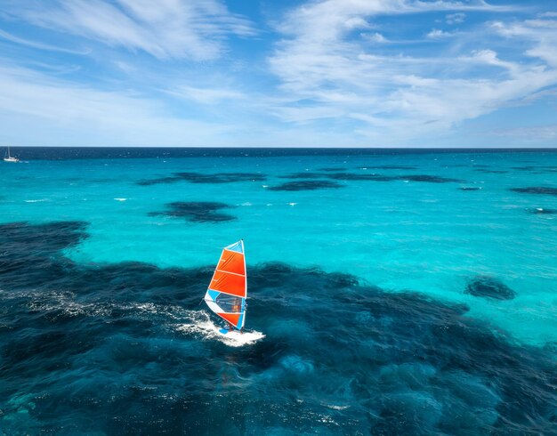 Foto vista aérea de um windsurfista no mar azul em um dia de verão ensolarado