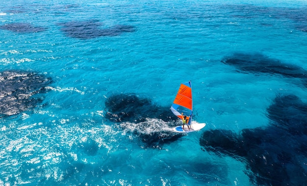 Vista aérea de um windsurfista no mar azul em um dia de verão ensolarado