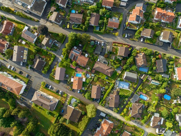 Vista aérea de uma área residencial com ruas e telhados em uma manhã de verão