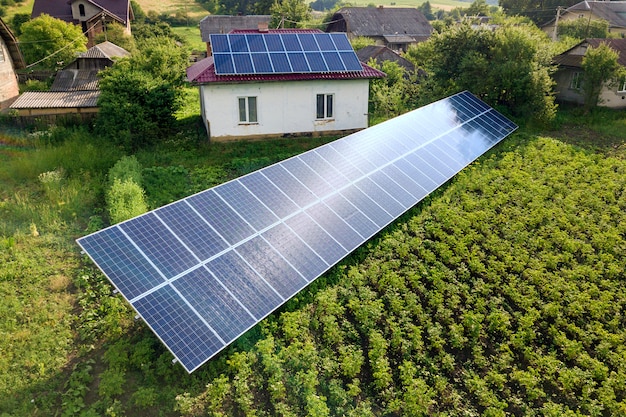 Vista aérea de uma casa com painéis solares azuis para energia limpa.