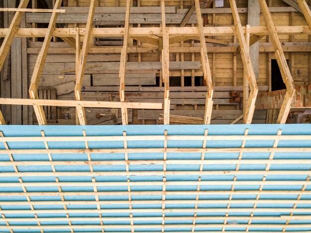 Vista aérea de uma casa de tijolos com estrutura de telhado de madeira em construção.