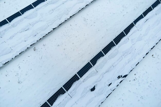 Vista aérea de uma central elétrica sustentável com painéis solares fotovoltaicos cobertos de neve no inverno para produzir energia limpa Conceito de baixa eficácia da eletricidade renovável no norte