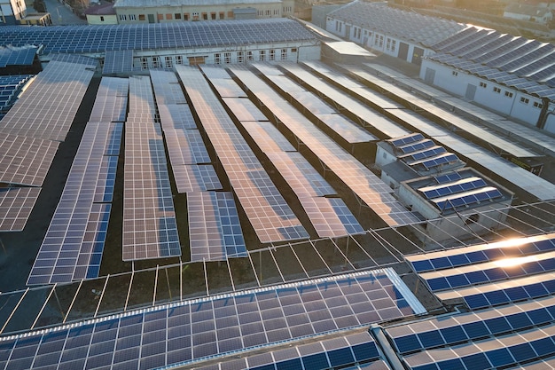 Vista aérea de uma central solar com painéis fotovoltaicos azuis montados no telhado de um edifício industrial para produzir eletricidade ecológica verde Produção de conceito de energia sustentável