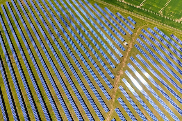 Vista aérea de uma grande usina elétrica sustentável com muitas fileiras de painéis solares fotovoltaicos para a produção de energia elétrica ecológica limpa. Eletricidade renovável com conceito de emissão zero.