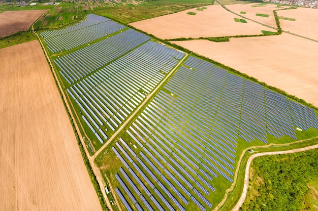 Vista aérea de uma grande usina elétrica sustentável com muitas fileiras de painéis solares fotovoltaicos para produzir energia elétrica ecológica limpa. Eletricidade renovável com conceito de emissão zero.