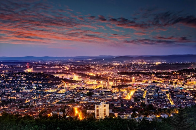 Vista aérea de uma paisagem urbana iluminada contra o céu ao pôr-do-sol