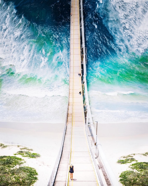 Foto vista aérea de uma ponte de pedestres pendurada sobre o mar