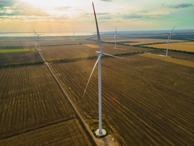 Vista aérea de uma turbina de ar em posição parada em um campo perto do mar